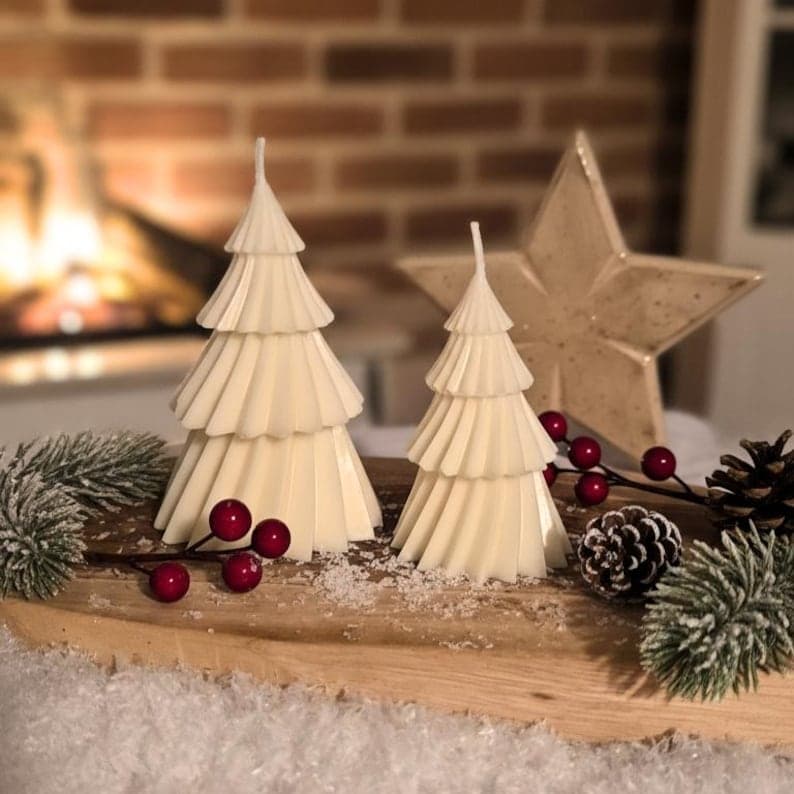 Zwei weiße Tannenbaum-Kerzen auf Holz